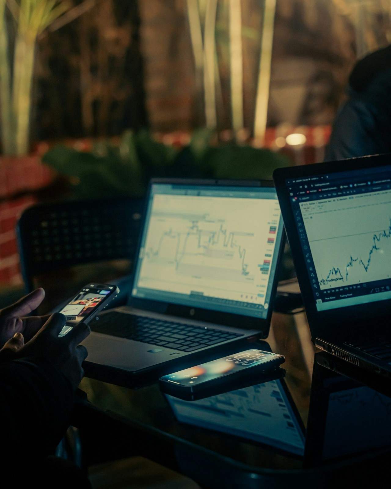 People working on laptops with financial charts at night